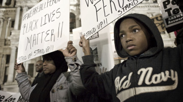 Philadelphia, PA USA - November 24, 2014; A young protester and his mother are seen holding signs at Dillworth Park at Philadelphia City Hall. (photo by Bas Slabbers)