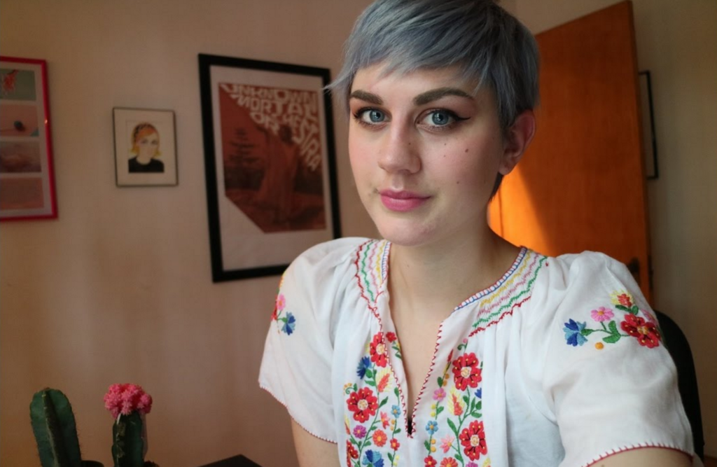 Vlogger Celia in a floral top, smiling slightly and gazing into the camera.